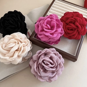 Pinces à cheveux en forme de rose 3D en tissu coloré sur un coffret à bijoux en bois