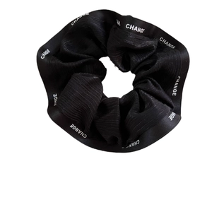 Elegant black scrunchie with white lettered satin edge for stylish hair styling