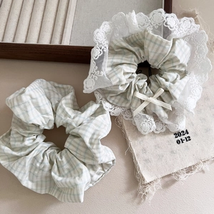 Détail de chouchous à carreaux vert menthe avec bordure en dentelle et petit nœud