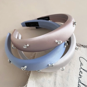 Detail of beaded satin headbands with pearls and crystals in pink, blue and cream white