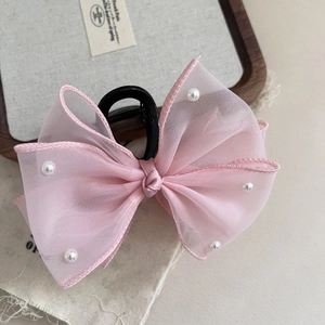 Close-up of pink tulle bow hair claw clip featuring elegant white pearl embellishments