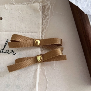 Pair of vintage bronze French bow hair clips with ribbed texture and golden accents