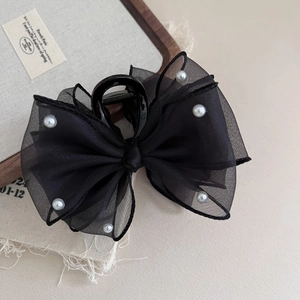 Detailed view of layered black mesh bow hair claw clip with elegant white pearls decoration