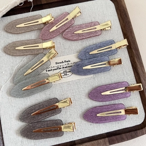 Close-up of a 12-piece set of shimmering acetate hair clips in assorted pastel colors