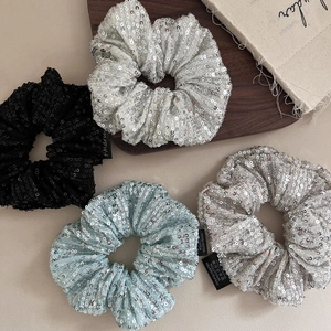 Set of four shiny sequin scrunchies in black, silver, white and blue for high-end hairstyling