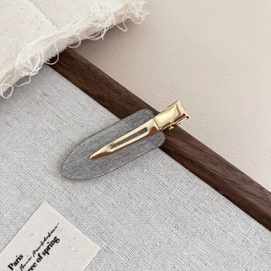 Elegant acetate hair clip with gray glitter finish and gold metal base on canvas background