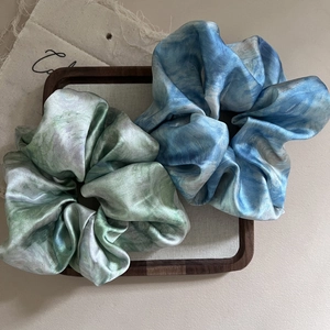 Detail of satin scrunchies with elegant blue and green oil painting marble texture