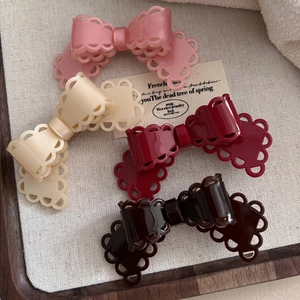 Detailed set of four acetate bow hair clips with delicate lace edges in varied soft colors