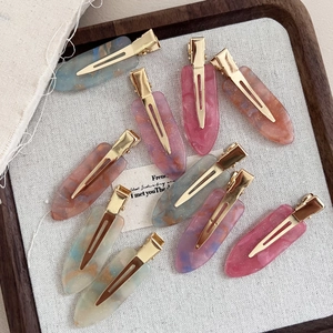 Marbled acetate hair clips set with gold metal base and pearlescent finish