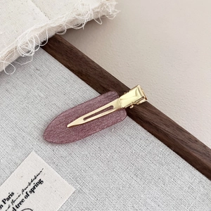 Detail of lavender acetate hair clip with glitter finish on a wooden display base