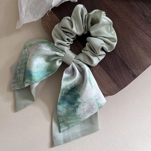 Detail of elegant satin hair scrunchie with blue watercolor oil painting floral pattern
