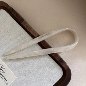 Makro-Detail der U-förmigen Haarnadel aus Acetat in perlweißem Marmor-Design