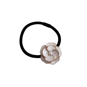 Elegant camellia hair tie with pink flower and pearl center on black elastic band
