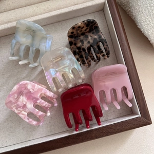 Detailed set of 6 acetate hair claws in leopard, red, and marble tones on display