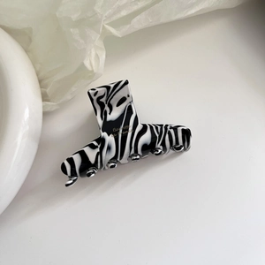 Vintage acetate hair claw with black and white marble pattern and gold lettering