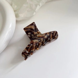 Detailed shot of amber acetate hair claw clip with Barrette La France lettering texture