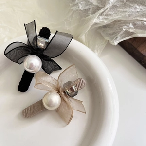 Détails de barrettes à nœuds en résille avec perles et cristaux noirs et champagne