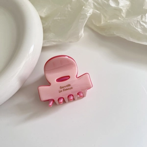 Detail of pink acetate hair claw with golden Barrette La France text engraving