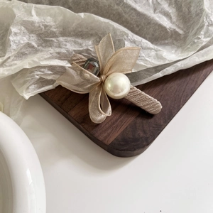 Barrette élégante en résille avec perle blanche et strass noir sur fond en bois vintage