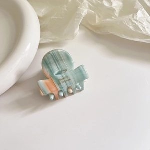 Detail of French style acetic acid hair claw with marble texture and logo engraving