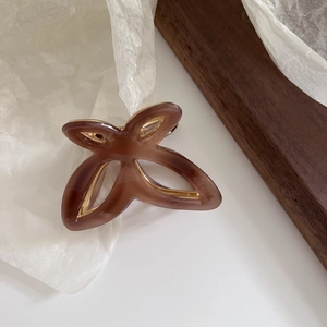 Detail view of the brown acetate butterfly hair claw clip with golden metal structure