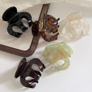 Five assorted acetate pumpkin hair claws in marble, tortoise shell, and solid colors