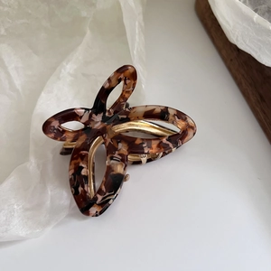 Detail of elegant butterfly hair claw clip with tortoise acetate and gold metal frame