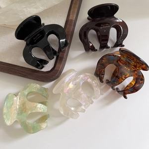 Detail view of five acetate hair claws in various marble and tortoiseshell patterns