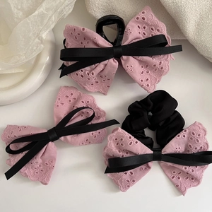 Detailed view of pink lace bow hair clip, claw clip and scrunchie set with black ribbons