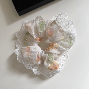 Vue détaillée du chouchou floral français avec bords en dentelle blanche délicate