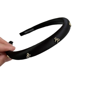 Elegante cerchietto in raso nero con dettaglio a fiocco in metallo dorato fatto a mano