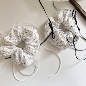 Close-up of elegant black and white polka dot hair scrunchies with satin ribbon bows