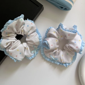 Detail of sweet ballet-style scrunchies with heart prints and blue gingham ruffled edges