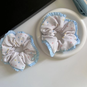 Close-up of ballet-style heart print scrunchies with light blue gingham ruffled edges