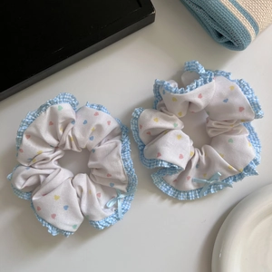Detailed macro view of two blue checkered heart scrunchies with elegant ribbon bows
