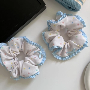 Set of two colorful heart print scrunchies with blue gingham lace edges and ribbon bows