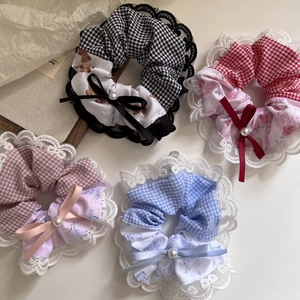 Detail of four plaid lace hair scrunchies with cute prints and pearl bow decorations