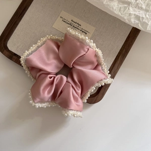 Elegant pink satin scrunchie with lace trim and pearls for stylish hair styling