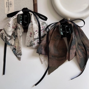 Close-up of ink-wash style silk ribbon hair claw clips with elegant Chinese patterns
