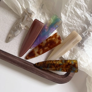 Detail showing set of six handmade acetate hair clips with amber and marble patterns