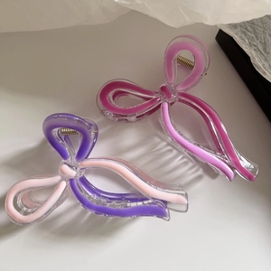 Detail of colorful bow-knot hair claws made of transparent acrylic in pink and purple