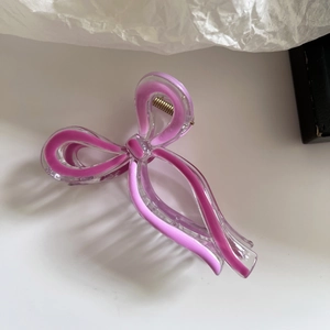 Detail of elegant purple ribbon bow hair claw with gold spring and fluid pattern