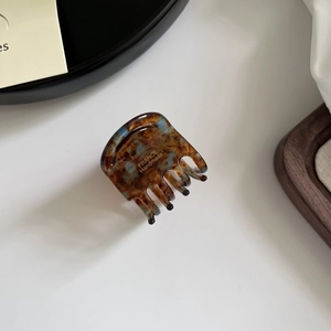 Detail view of acetate claw clip with amber texture and France Handmade gold lettering
