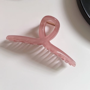 Detailansicht der rosa transparenten Haarklammer mit Metallfeder und großen Zähnen