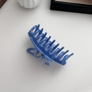 Detailed close-up of blue marble pattern butterfly hair claw with metal spring