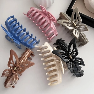 Detail view of large butterfly hair claws in six colors with marble texture finish