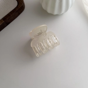 Detail view of a creamy beige matte hair claw clip with a strong metal spring mechanism