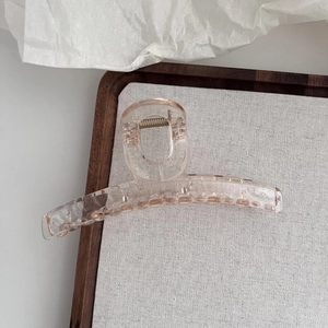 Détail de la pince à cheveux rose translucide de 13cm avec ressort en métal doré