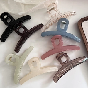 Vue de dessus de pinces à cheveux 13cm en 8 couleurs jelly sur fond blanc et bois