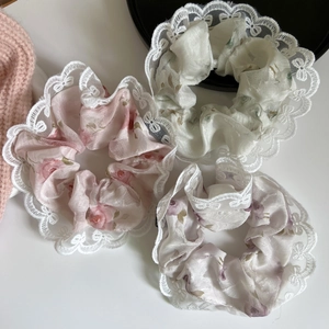 Vista macro dettagliata di tre elastici per capelli in pizzo con eleganti motivi a rose